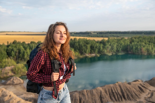 Молодая кавказская женщина, походы с рюкзаком в солнечный день