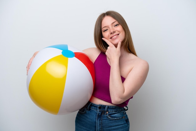 Young caucasian woman holding beach ball isolated on white background happy and smiling