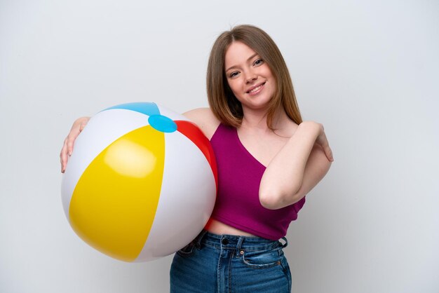 Young caucasian woman holding beach ball isolated on white background laughing