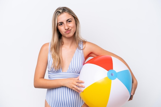 Young caucasian woman holding beach ball isolated on white background with sad expression