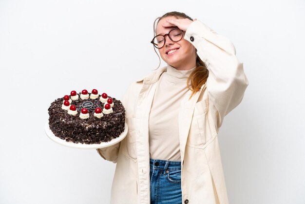 たくさんの笑みを浮かべて白い背景で隔離のバースデー ケーキを保持している若い白人女性