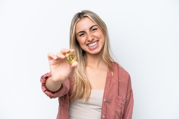 행복 한 표정으로 흰색 배경에 고립 된 Bitcoin을 들고 젊은 백인 여자