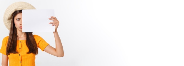 Photo young caucasian woman holding blank paper sheet over isolated background scared in shock with a surp