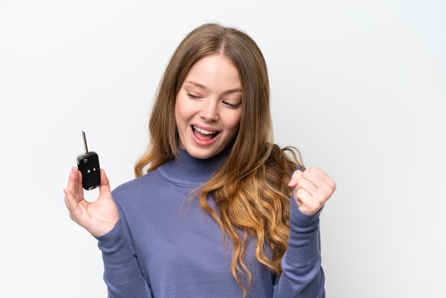 Young caucasian woman holding car keys isolated on white background celebrating a victory