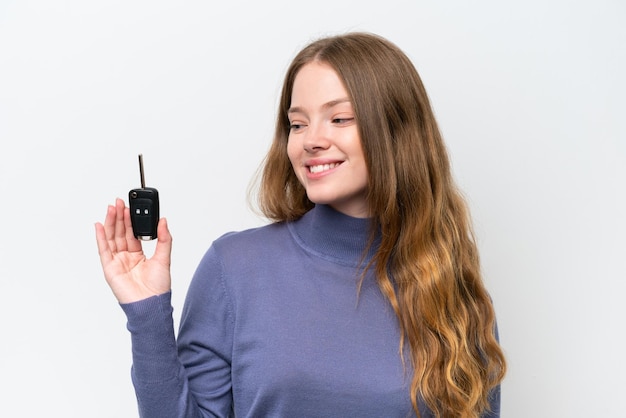 Young caucasian woman holding car keys isolated on white background with happy expression