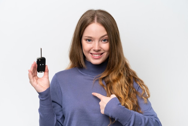 Young caucasian woman holding car keys isolated on white background with surprise facial expression