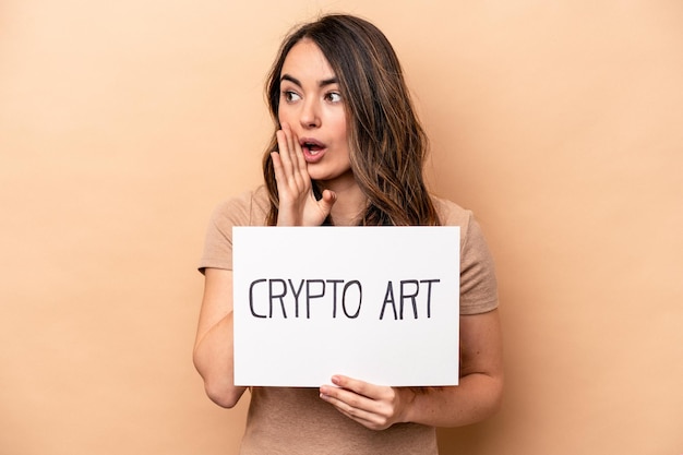 Young caucasian woman holding a crypto art placard isolated on beige background is saying a secret hot braking news and looking aside