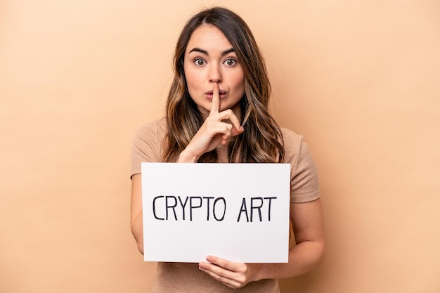 Young caucasian woman holding a crypto art placard isolated on beige background keeping a secret or asking for silence