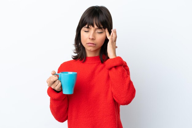 頭痛と白い背景で隔離のコーヒーのカップを保持している若い白人女性