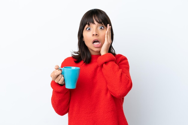 Young caucasian woman holding cup of coffee isolated on white background with surprise and shocked facial expression