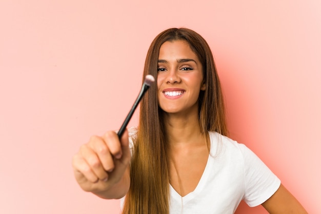 Giovane donna caucasica che tiene un eyebrush isolato