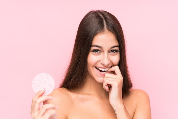 Young caucasian woman holding a facial disk isolated relaxed thinking about something looking at a copy space.