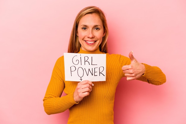 Photo young caucasian woman holding girl power placard isolated on pink background