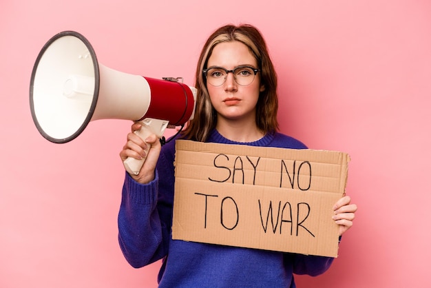 Молодая кавказская женщина с плакатом "Нет войне" на розовом фоне