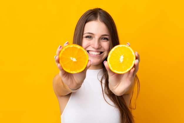 Young caucasian woman holding an orange on orange