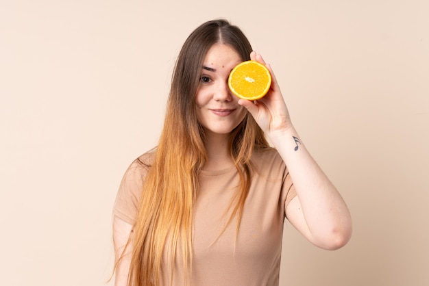 Young caucasian woman holding an orange