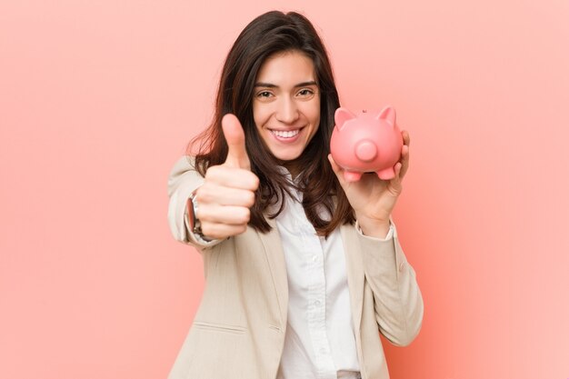 Young caucasian woman holding a piggy bank