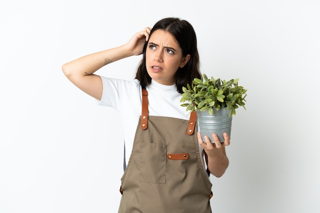 Young caucasian woman holding a plant isolated