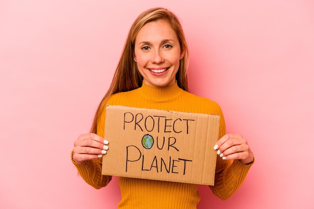 Young caucasian woman holding protect our planet placard isolated on pink background