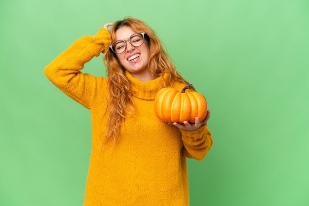 グリーン スクリーン クロマ キー背景に分離されたカボチャを保持している若い白人女性