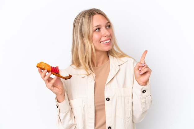 Foto giovane donna caucasica che tiene sashimi isolato su sfondo bianco che indica una grande idea