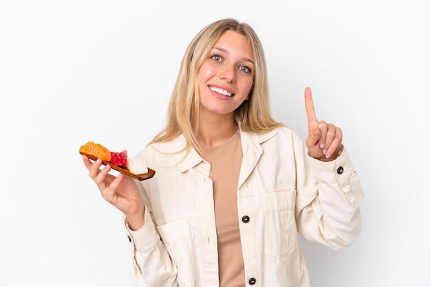 Young caucasian woman holding sashimi isolated on white background pointing up a great idea