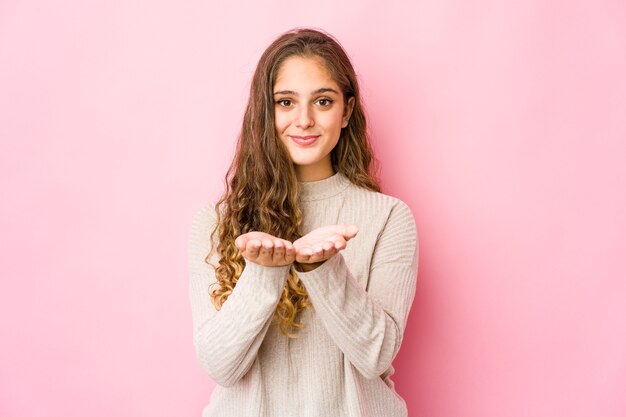 Young caucasian woman holding something with palms