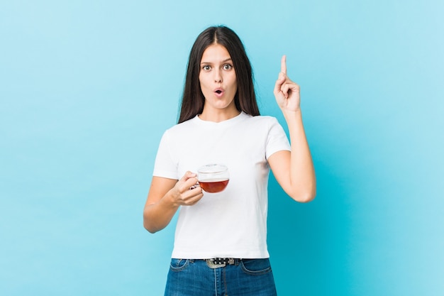 Young caucasian woman holding a tea cup having some great idea, concept of creativity.