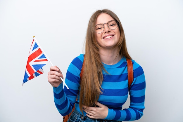 Young caucasian woman holding an United Kingdom flag isolated on white background smiling a lot