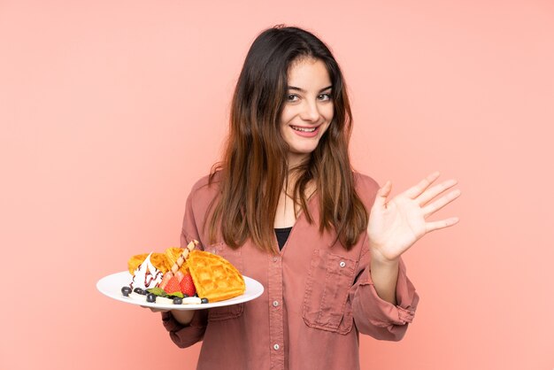 Young caucasian woman holding waffles