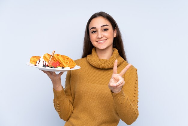 Young caucasian woman holding waffles