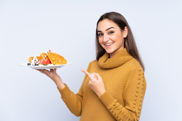 Young caucasian woman holding waffles