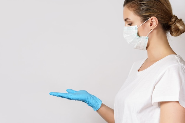 Young caucasian woman is wearing a face mask and latex gloves for protection against virus