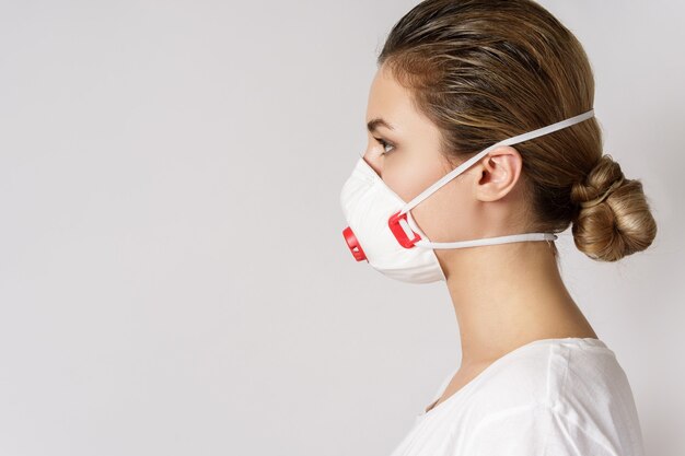 Молодая кавказская женщина носит маску для защиты от вируса