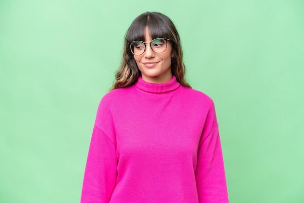 young caucasian woman over isolated background having doubts while looking side