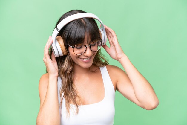 Foto giovane donna caucasica sopra musica d'ascolto isolata del fondo