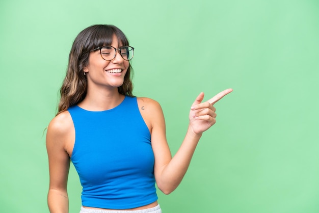 Young caucasian woman over isolated background pointing finger to the side and presenting a product