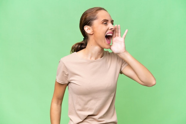 Photo young caucasian woman over isolated background shouting with mouth wide open to the side