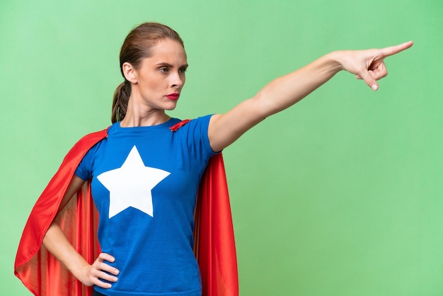 Young caucasian woman over isolated background in superhero costume with proud gesture