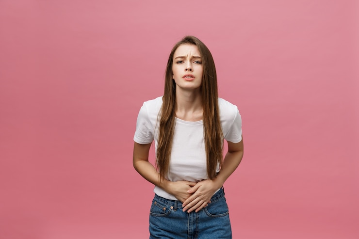 Photo young caucasian woman over isolated background with hand on stomach because indigestion