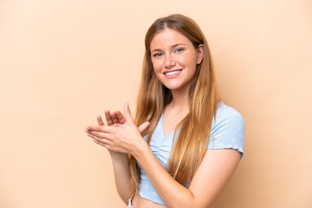 Photo young caucasian woman isolated on beige background applauding