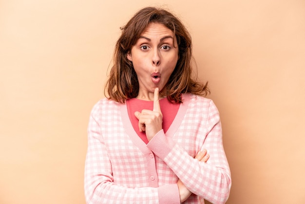 Young caucasian woman isolated on beige background having some great idea concept of creativity