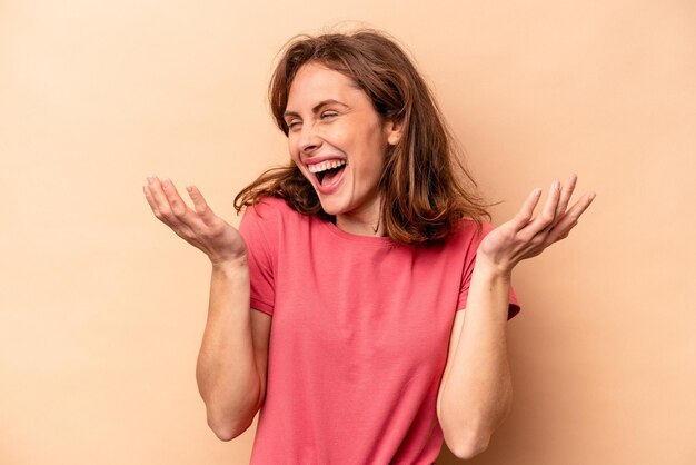 Young caucasian woman isolated on beige background joyful laughing a lot Happiness concept