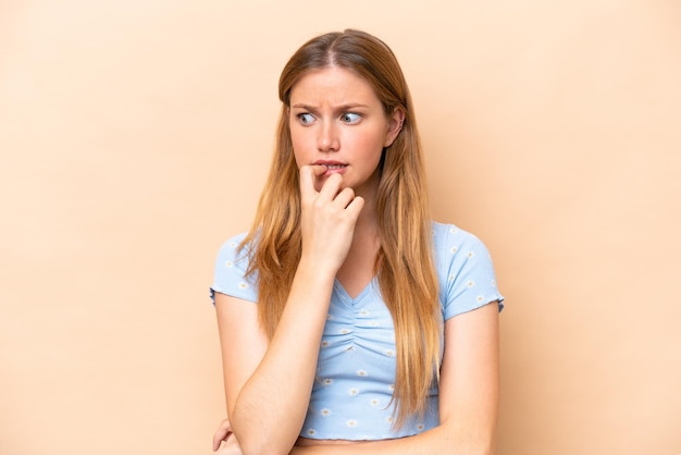 Young caucasian woman isolated on beige background nervous and scared