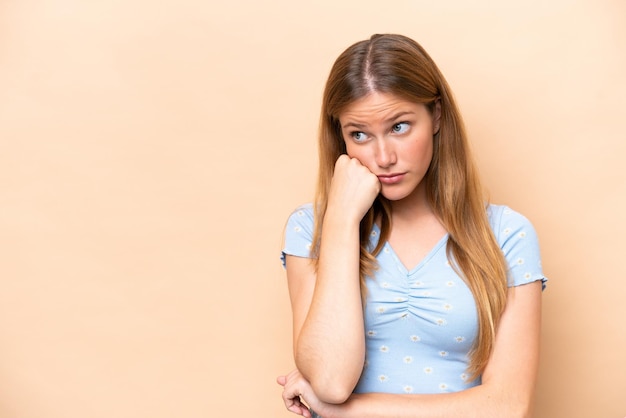 Photo young caucasian woman isolated on beige background with tired and bored expression