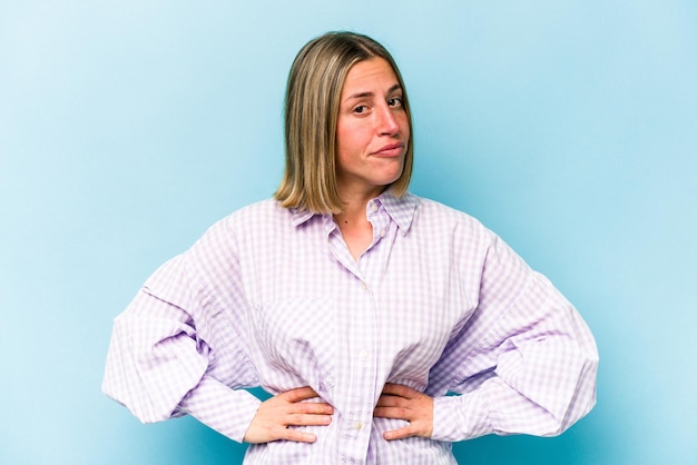 Photo young caucasian woman isolated on blue background confused feels doubtful and unsure