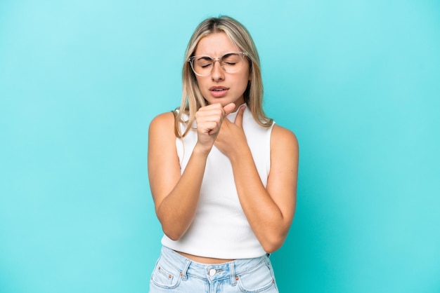 Young caucasian woman isolated on blue background coughing a lot