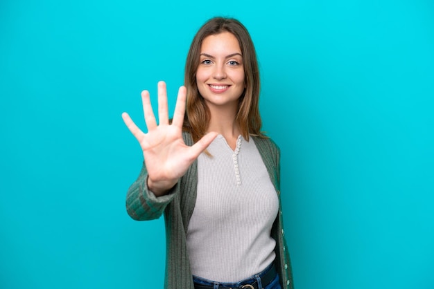 Young caucasian woman isolated on blue background counting five with fingers