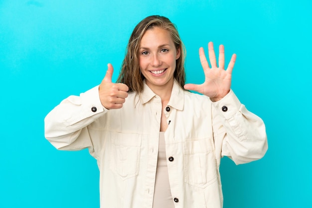 Young caucasian woman isolated on blue background counting six with fingers