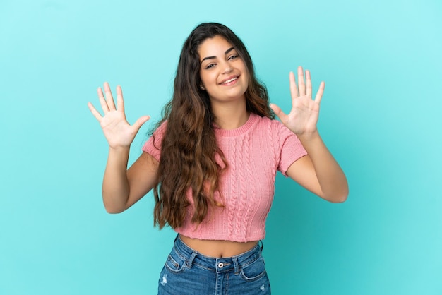 Young caucasian woman isolated on blue background counting ten with fingers